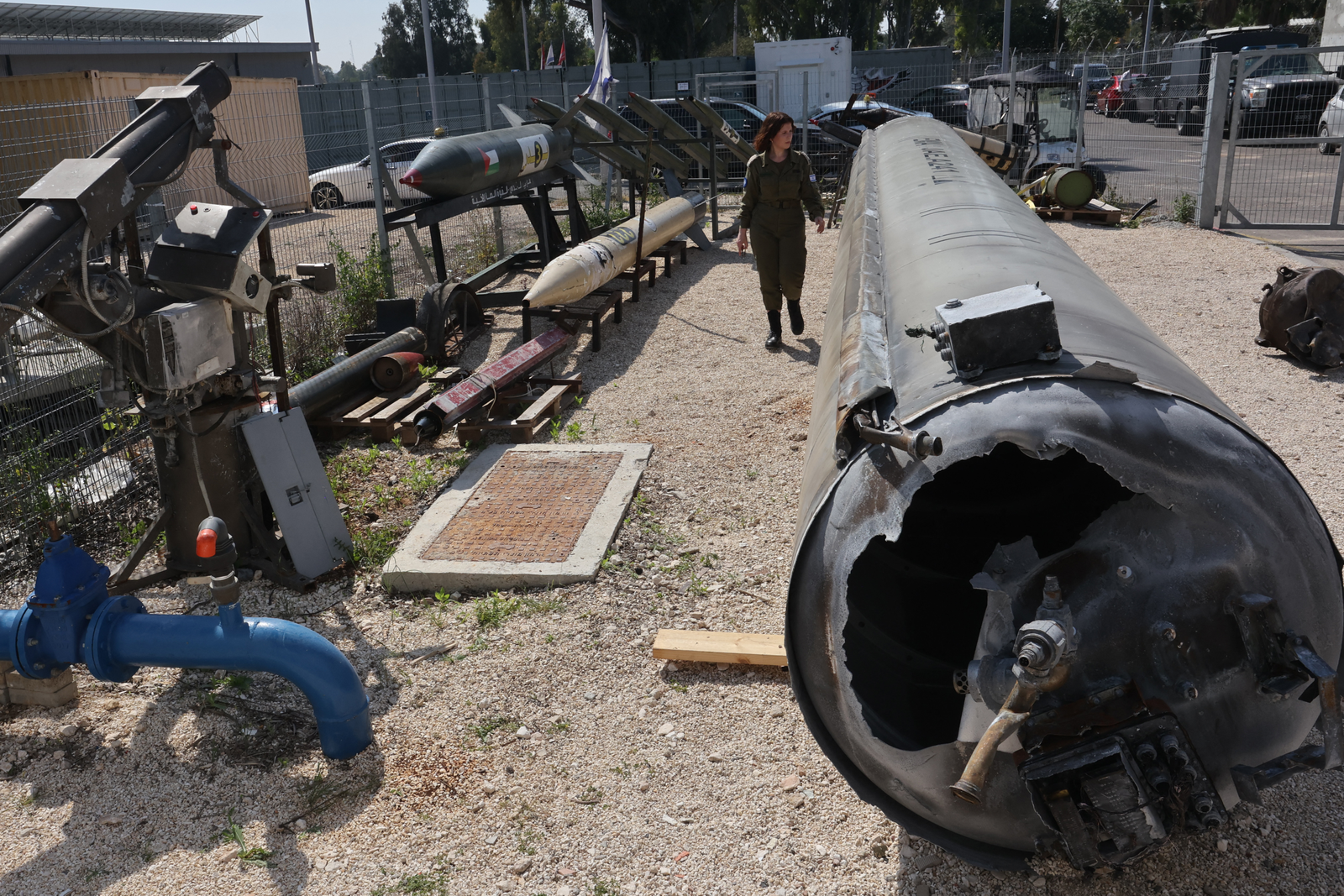 Membro do Exército de Israel passa por um míssil balístico iraniano que caiu em território israelense no ataque do dia 13 de abril — Foto: Gil Cohen-Magen/AFP