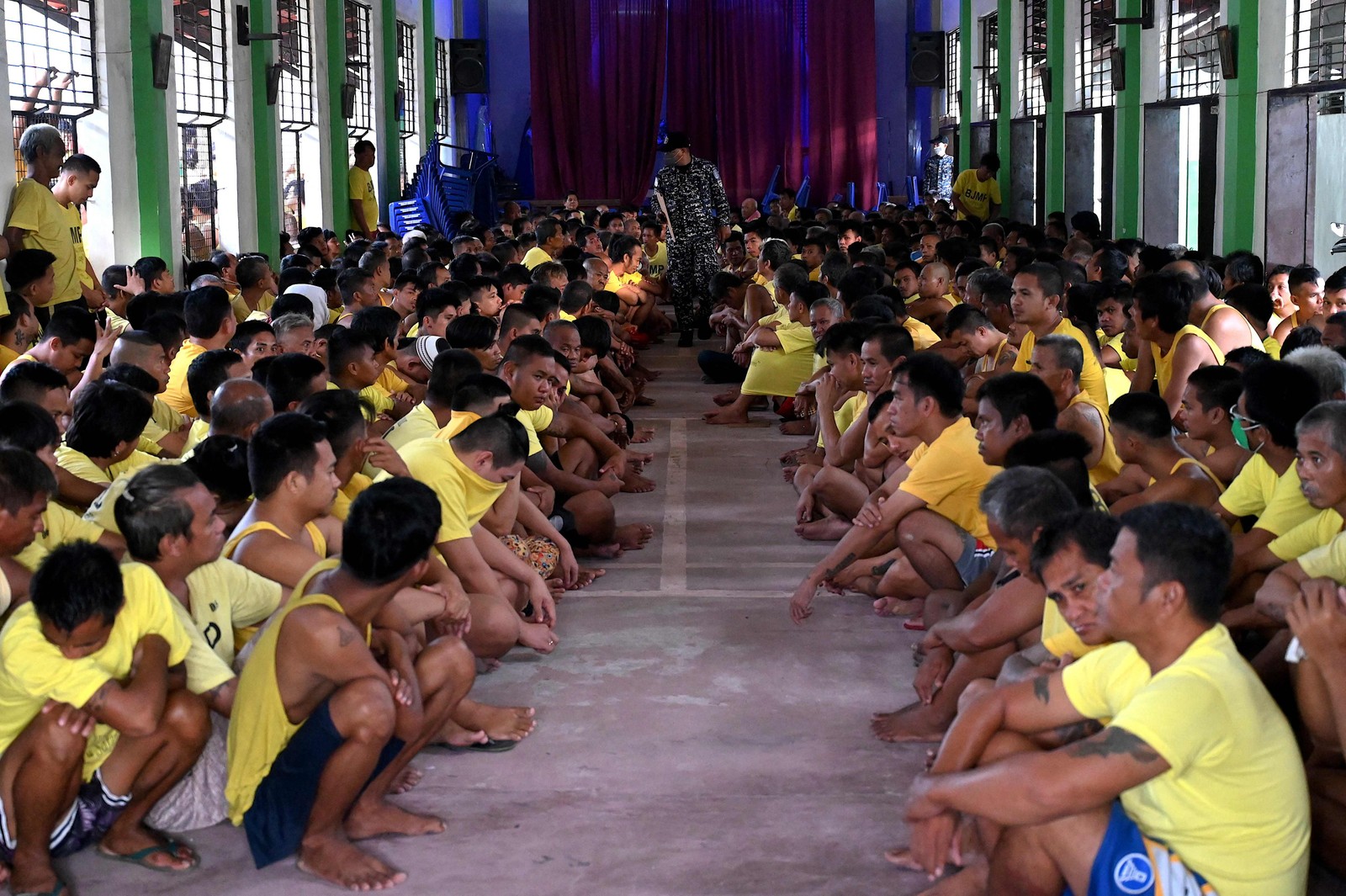 Presos aguardam em uma capela enquanto a polícia realiza busca nas celas por contrabando e drogas ilegais na prisão, em Manila — Foto: JAM STA ROSA / AFP