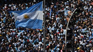 orcedores da Argentina esperam o ônibus com os jogadores da Argentina para passar pelo Obelisco para comemorar após vencer a Copa do Mundo do Catar 2022 em Buenos Aires — Foto: Luis ROBAYO / AFP