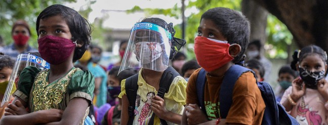 Alunos, usando EPI contra o coronavírus, retornam as aulas presenciais em escola do governo em Hyderabad, na ÍndiaAFP