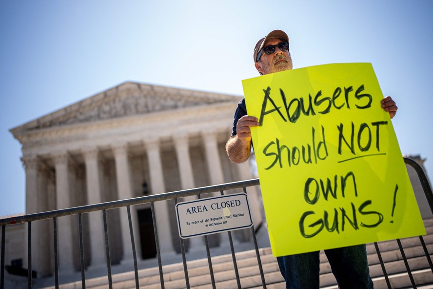 Manifestante segura cartaz escrito 'abusadores não devem ter armas', diante da Suprema Corte dos EUA