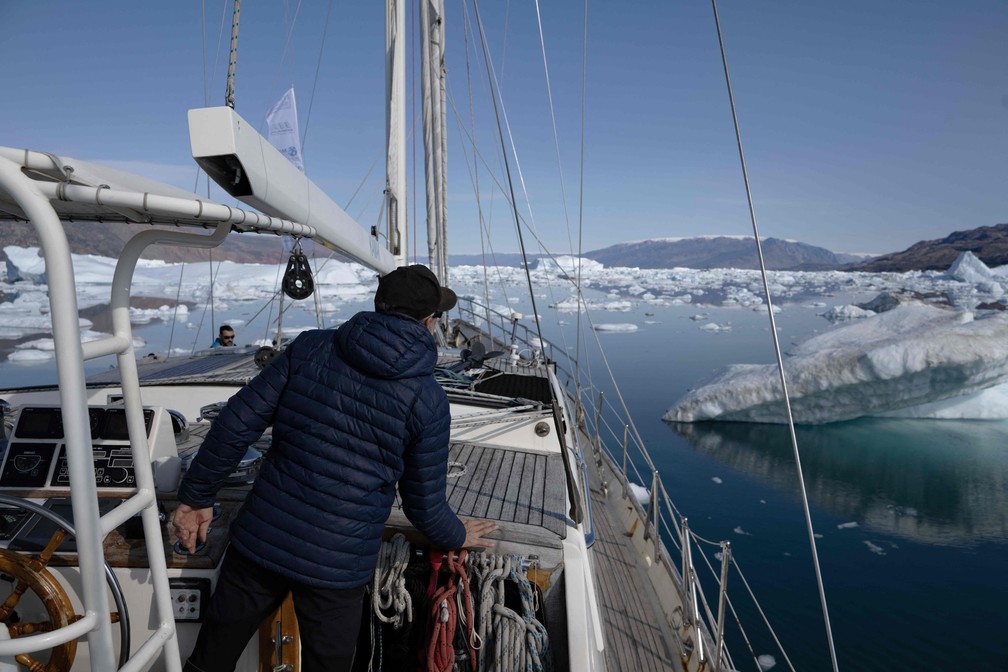 O capitão do 'Kamak', o francês David Delample, procura um caminho entre os icebergs liberados pelas geleiras ao redor de Milne Land no fiorde Scoresby Sound, leste da Groenlândia. — Foto: Olivier MORIN/AFP