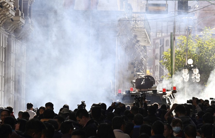 Tropas militares em veículos blindados disparam gás lacrimogêneo contra pessoas do lado de fora do Palácio Quemado, na Praça Murillo, em La Paz