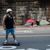 Homem passa de skate por tendas enquanto aumenta o número de acampamentos de sem-teto em Washington, DC - BRENDAN SMIALOWSKI/AFP