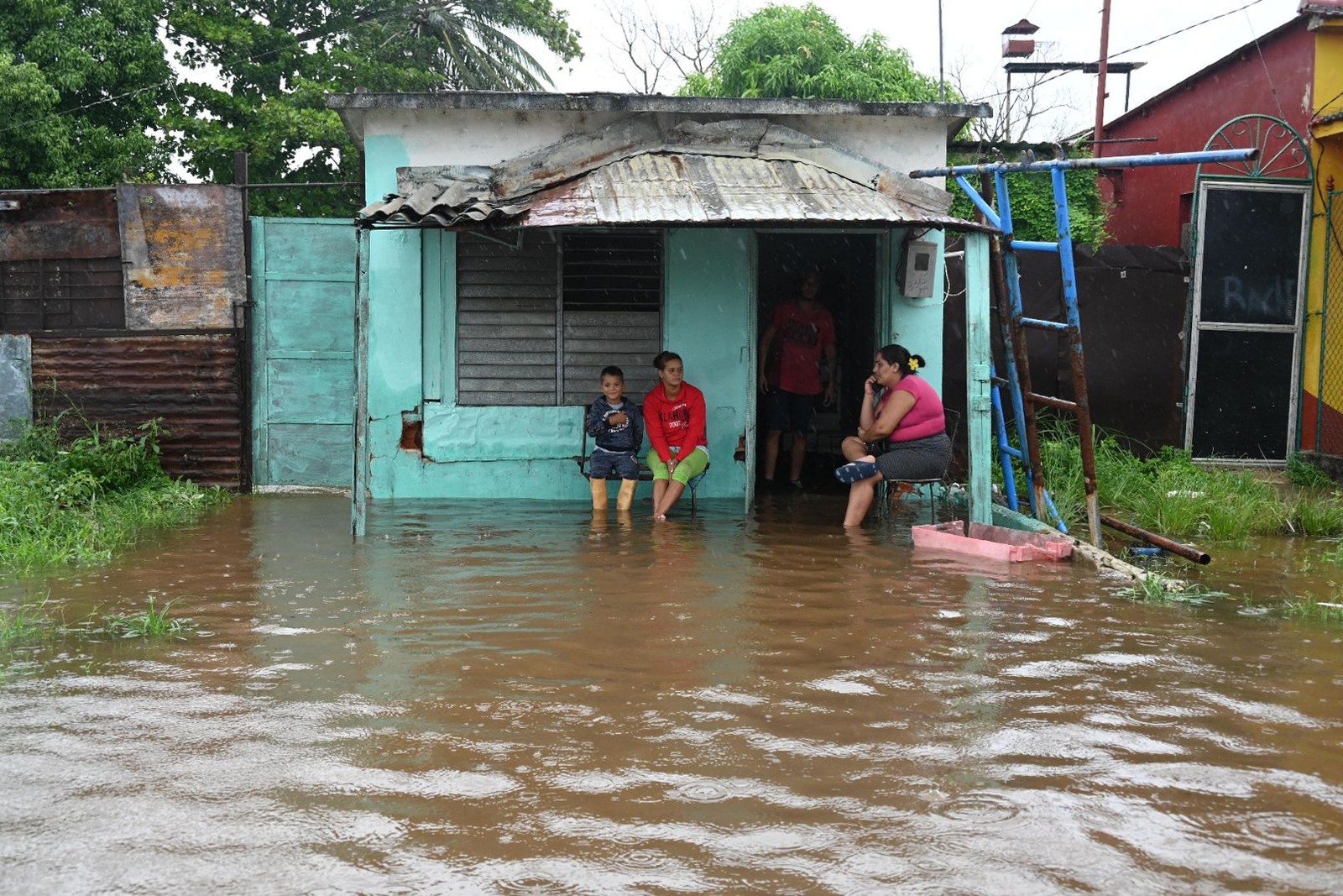 Pessoas ficam ilhadas em suas casas em área alagada de Batabano, província de Mayabeque (Cuba), durante a passagem da tempestade tropical Idalia. — Foto: Yamil LAGE/AFP