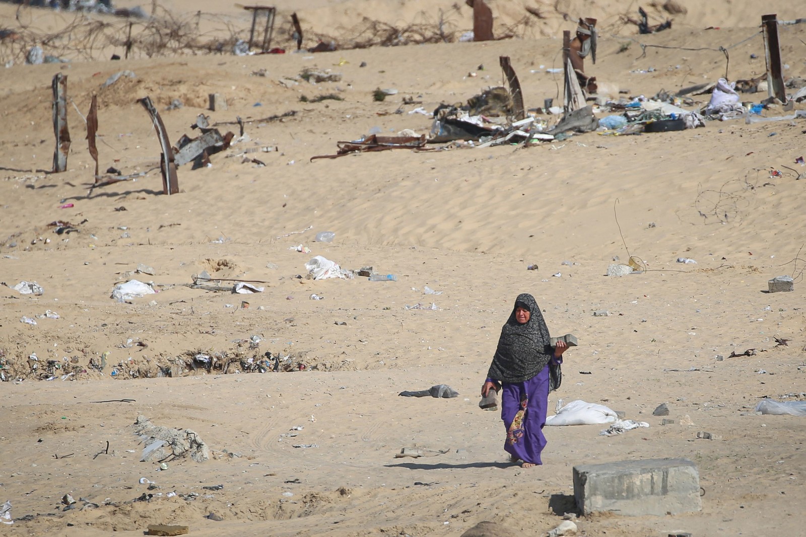 Mulher caminha em local onde havia campo de refugiados em Rafah, na Faixa de Gaza — Foto: AFP