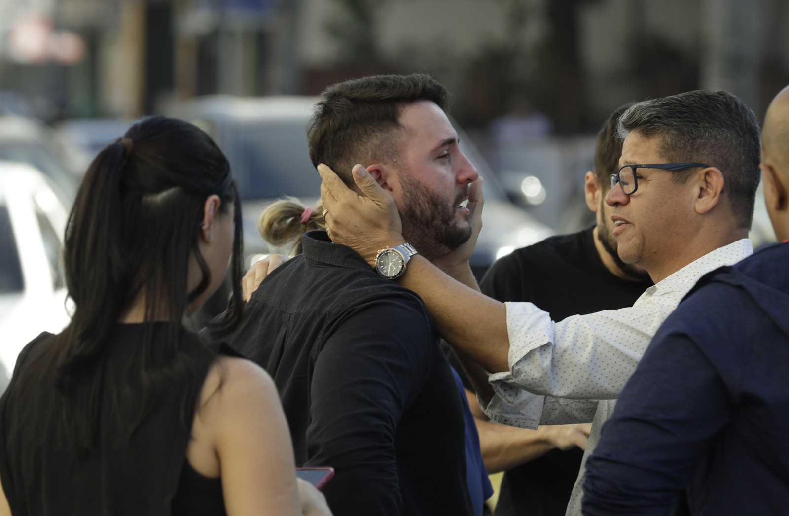 O marido de uma das vítimas é consolado — Foto: Gabriel de Paiva / Agência O Globo