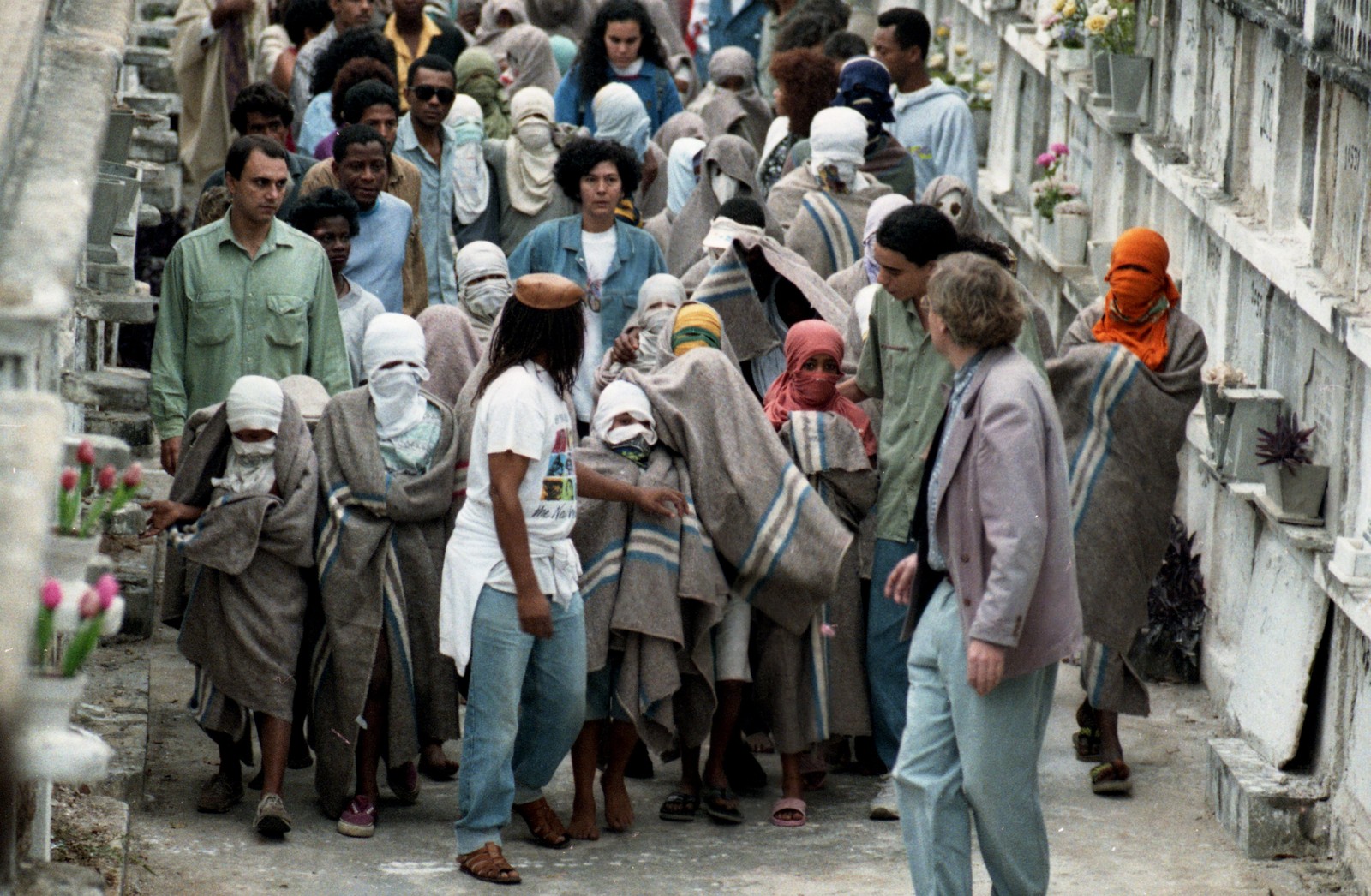 Adolescentes com rostos cobertos acompanham enterro de seus colegas no Cemitério do Caju, em 27 de julho de 1993  — Foto: Fernando Maia / Agência O Globo