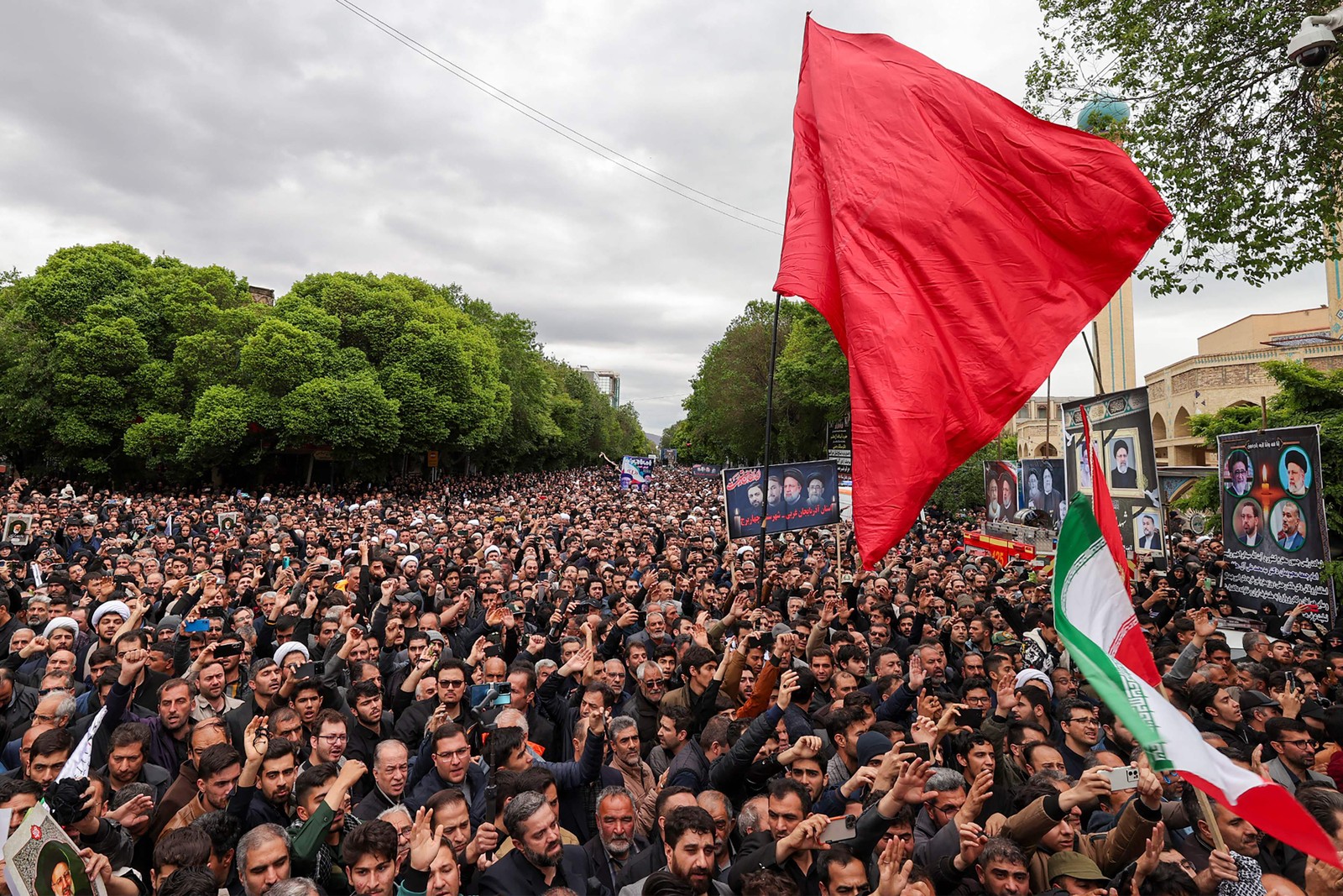 Esta foto fornecida pelo gabinete do presidente iraniano mostra pessoas em luto caminhando no cortejo fúnebre em Tabriz, capital da província iraniana do Azerbaijão Oriental, em 21 de maio de 2024, do falecido presidente Ebrahim Raisi e sete outras pessoas mortas com ele em um acidente de helicóptero. — Foto: Presidência Iraniana / AFP