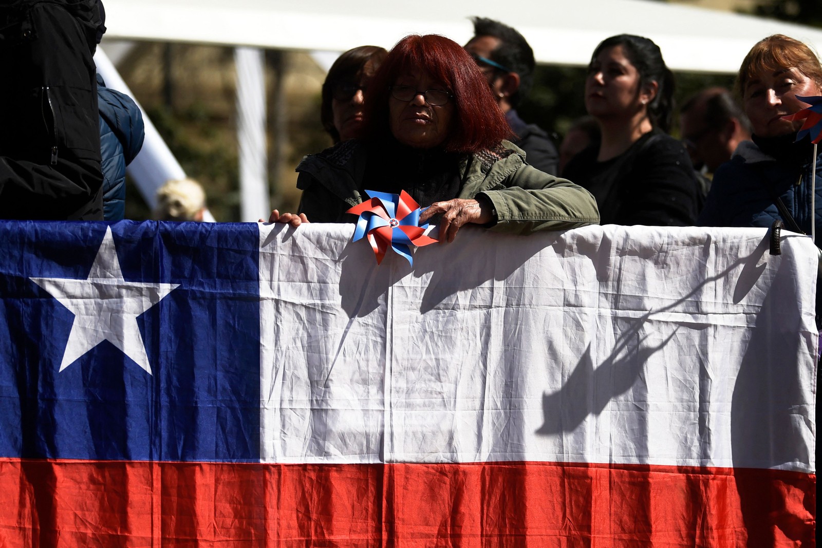 Pessoas participam de cerimônia que marca os 50 anos da ditadura chilena em frente ao Palácio Presidencial La Moneda, em Santiago. — Foto: Pablo VERA/AFP