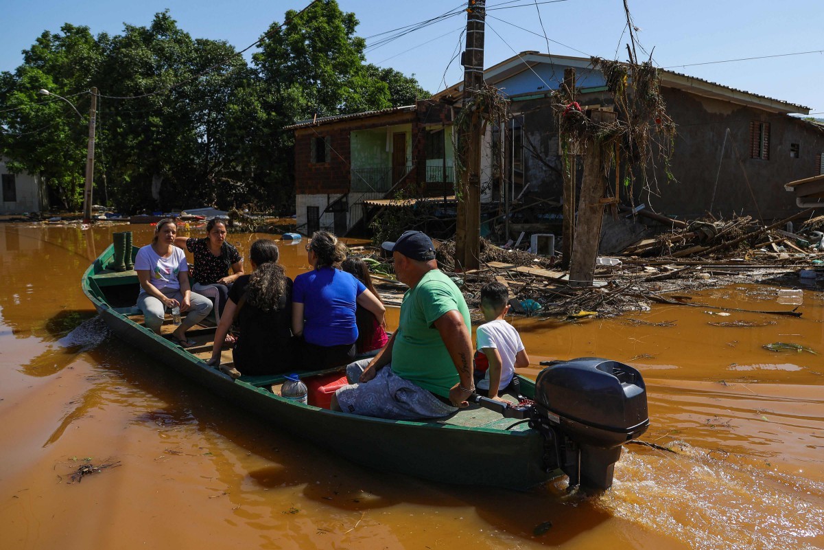 Moradores andam de lancha em um bairro inundado em Encantado, Rio Grande do Sul, no último dia 19 — Foto: SILVIO AVILA / AFP