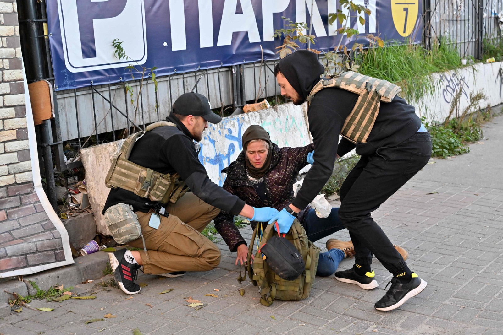 Médicos prestam ajuda a uma moradora que tenta fugir durante o intenso ataque russo à capital da Ucrânia — Foto: Sergei SUPINSKY / AFP