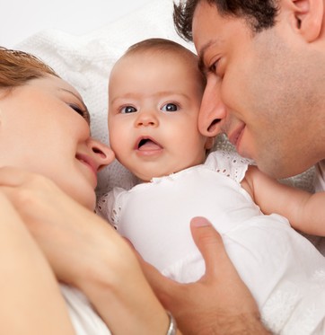 Casal deitado com o bebê (Foto: Shutterstock)