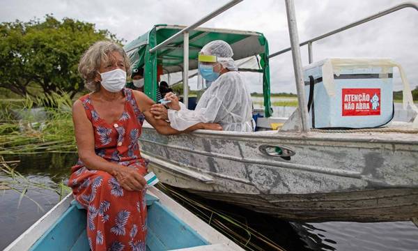 Olga D'arc Pimentel, 72 anos, é vacinada contra Covid-19, na comunidade Nossa Senhora Livramento, às margens do Rio Negro, perto de Manaus, Amazonas