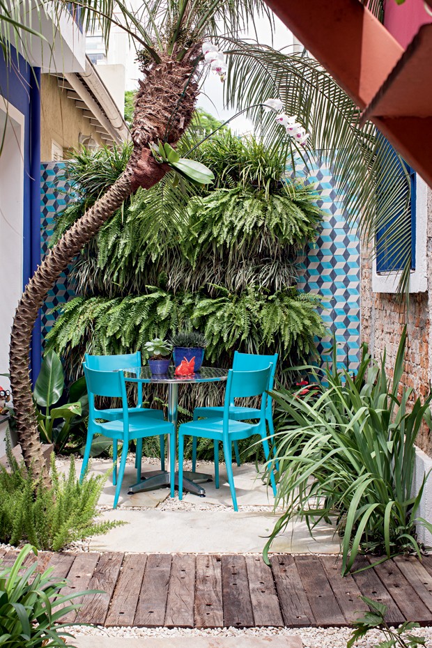 Ocantinho entre a cozinha do escritório e a sala de reuniões ganhou mesa e cadeiras da Tok & Stok e um jardim vertical com samambaias e barbas-de-serpente intercaladas. Nas laterais, ladrilhos hidráulicos da Ladrilar.  (Foto: Gui Morelli/Editora Globo)