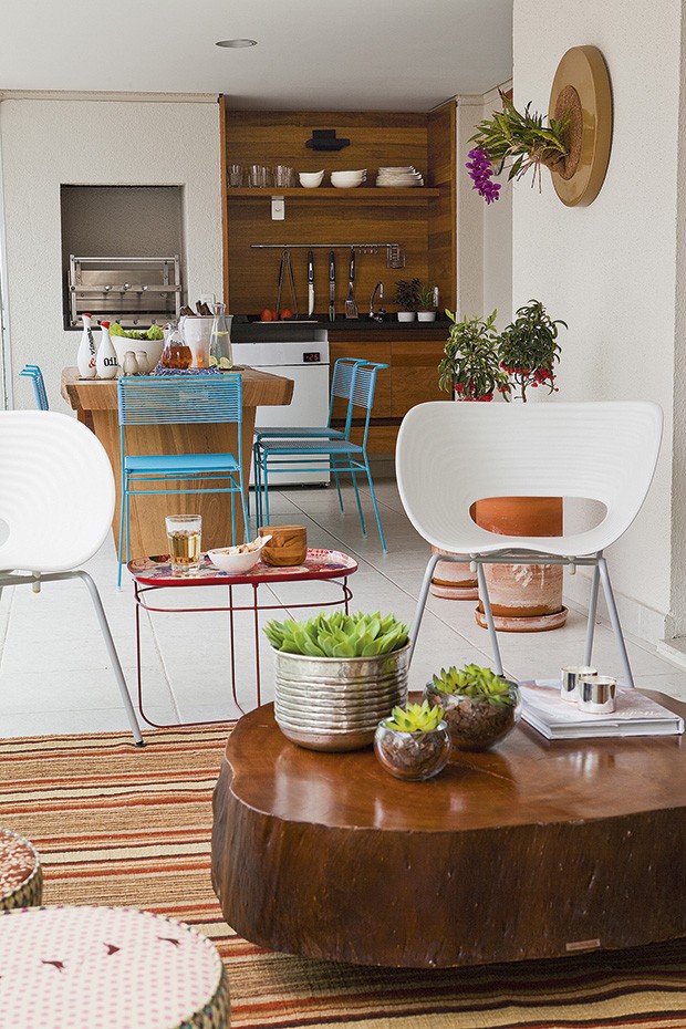 A varanda e a cozinha externa, com jeito de casa, são alegres e despojadas. A mesa é de madeira sustentável e as cadeiras Spaghetti são do designer Fernando Jaeger. De cumaru, a marcenaria foi desenhada pela arquiteta Tininha Loureiro (Foto: Edu Castello / Casa e Jardim)