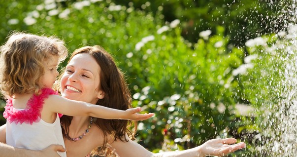 Mãe e filha brincando com água na natureza (Foto: Shutterstock)