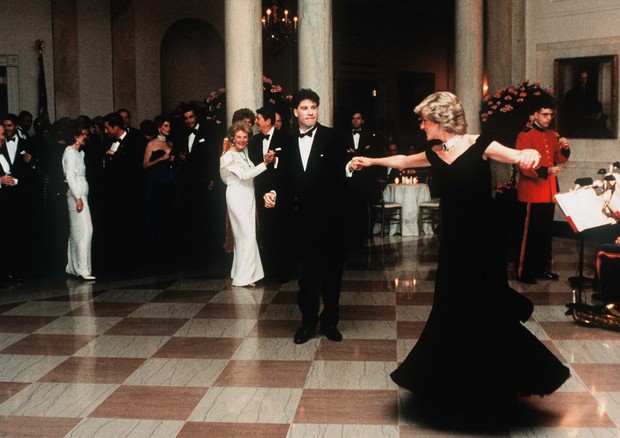 John Travolta twirls Princess Diana on the dance floor while at a White House banquet. Ronald and Nancy Reagan can be seen in the background. (Photo by © Pool Photograph/Corbis/Corbis via Getty Images) (Foto: Corbis via Getty Images)