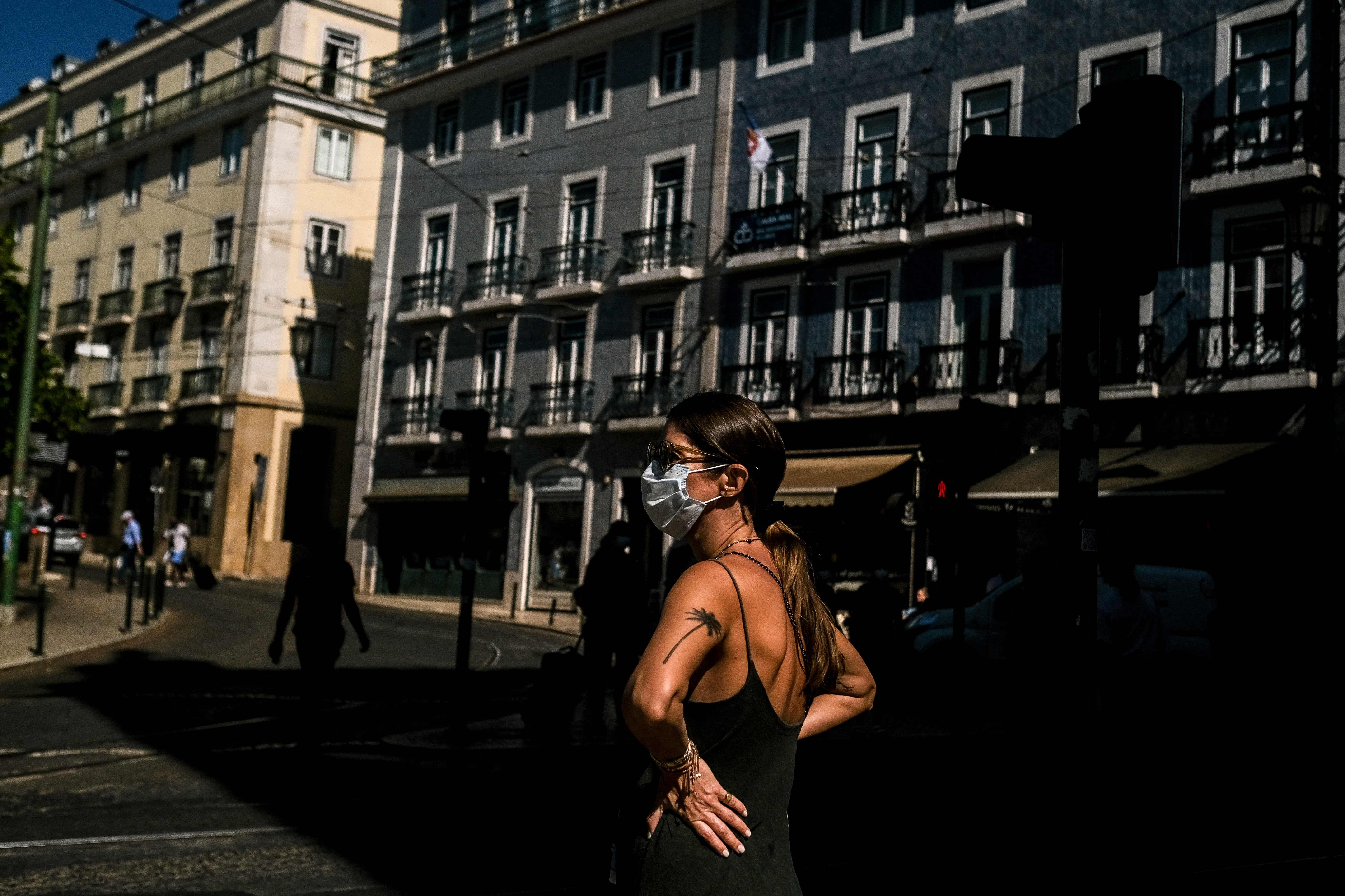 Mulher de máscara na Praça Camões, em Lisboa