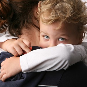 Criança triste no colo da mãe (Foto: Shutterstock)