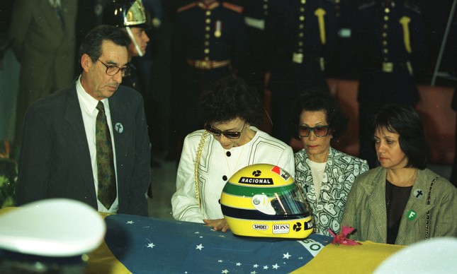 Pai e mãe de Senna, com duas amigas, junto ao caixão e ao capacete de Senna