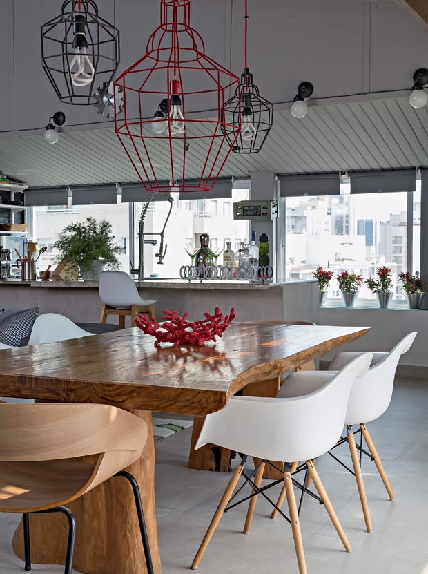 Sala de jantar | Mesa da Espaço Til com cadeiras DAR Eames. Nas cabeceiras, cadeiras Grácia, linha Fetiche, da Artesian. Banqueta Plopp, da Marché Art de Vie. Pendentes da coleção Riviera, de Paola Navone, da Crate&Barrel (Foto: Evelyn Müller/Divulgação)