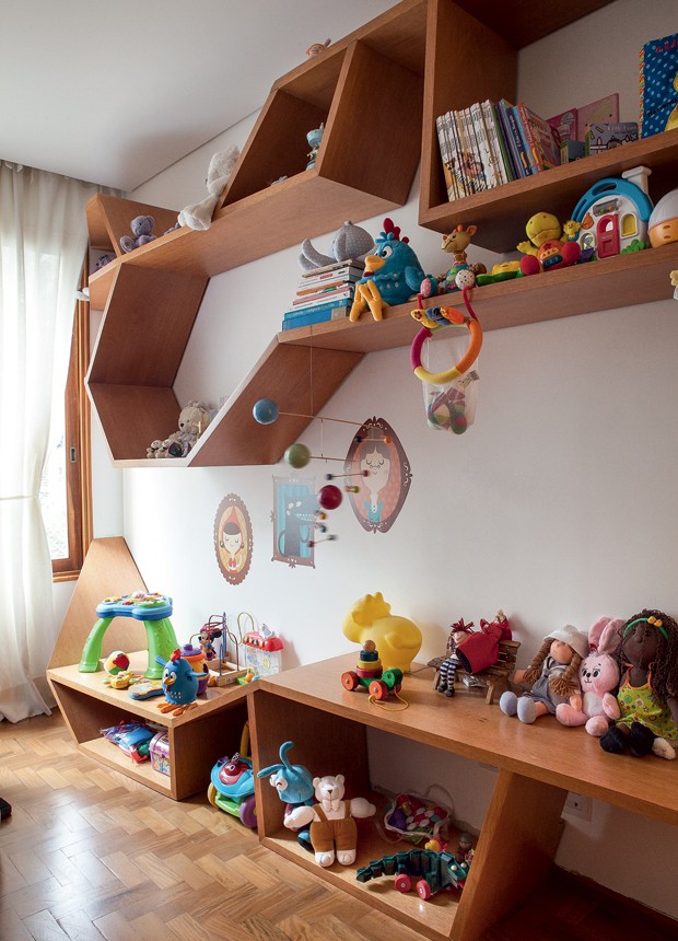 Os brinquedos ficam na estante angular, criada por Thiago Passos e feita de freijó pela Marcenaria Lanzili. O móvel veio do antigo apartamento do casal (Foto: Lufe Gomes/Editora Globo)