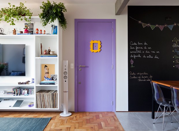 Além da porta inspirada no seriado Friends que foi o primeiro pedido da moradora, os objetos decorativos  que se espalham pela sala já pertenciam ao casal e ajudam a contar a história deles (Foto: Maira Acayaba)