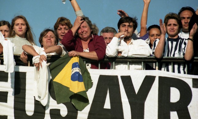 Admiradores de Ayrton Senna choram enquanto assistem a passagem de cortejo fúnebre