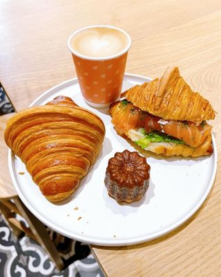 Photo of Maison Nico - San Francisco, CA, US. Croissant, salmon croissant sandwich, canele, oat milk cappuccino