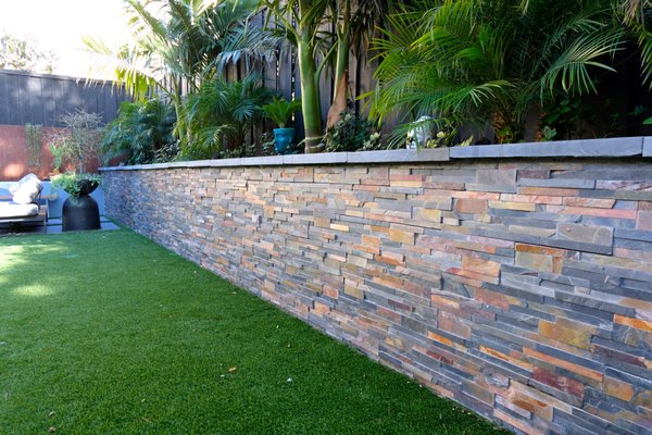 Photo of RB landscaping - Redwood City, CA, US. Cinderblock (CMU) retaining wall with natural stone veneer finish.