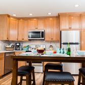 This warm and inviting kitchen in San Jose features alder wood cabinets with marbled white quartz countertops.