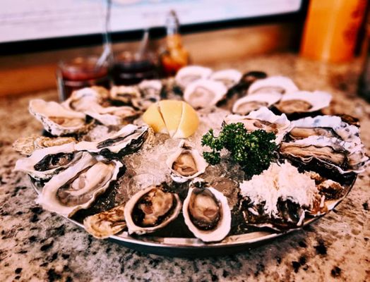 Photo of Oyster Express - Vancouver, BC, CA. a platter of oysters with a lemon wedge