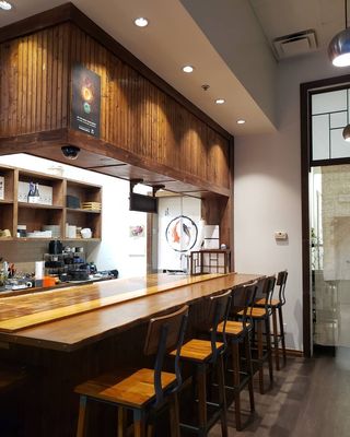 Photo of Sushi Jin - Vancouver, BC, CA. a bar with wooden counter tops and stools