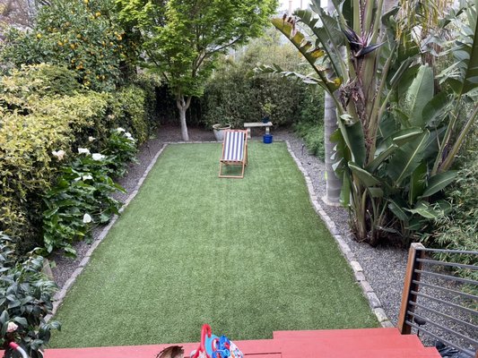 Photo of Blooms Gardening - San Francisco, CA, US. Nice backyard with artificial grass and beautiful surrounding plants.