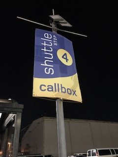 Photo of San Francisco Bay Oakland International Airport Parking Lot - Oakland, CA, US. a shuttle stop sign