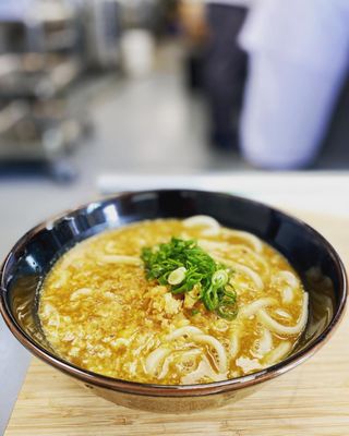 Photo of Motonobu Udon - Vancouver, BC, CA. a bowl of soup on a chopping board
