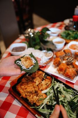 Photo of Crab Hot Lau - Vancouver, BC, CA. a person grabbing a piece of food from a plate