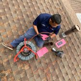 Inspecting a roof vent drain line.