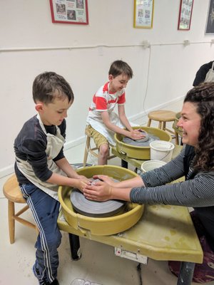 Photo of Kids 'N' Clay Pottery Studio - Berkeley, CA, US. The boys getting a lesson on how to use the potters wheel and brushing on the glaze after their bowls we're finished.