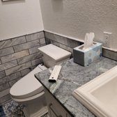 Here, you can see the new toilet with a tile wainscoting and the new counter top on the vanity 