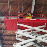 Service technicians on a lift to install bird netting at a commercial site. 