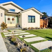 Stepping stones paired with artificial turf for a neat, green look. Perfect blend of nature & convenience. #OutdoorStyle #EcoFriendly"