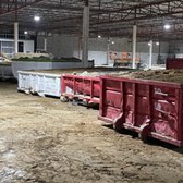 Several dumpster for concrete and soil 
