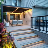 Close-up of the contemporary deck in Bayside, highlighting LED step lighting and a vibrant flower bed, designed by Vandeck.