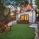 Artificial grass area, with cable railing, concrete path, and wood steps