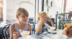 Kids are eating delicious italian ice cream at cafe in Rome, Italy. Kids aged 10 and 7 are visiting Rome on summer vacations.