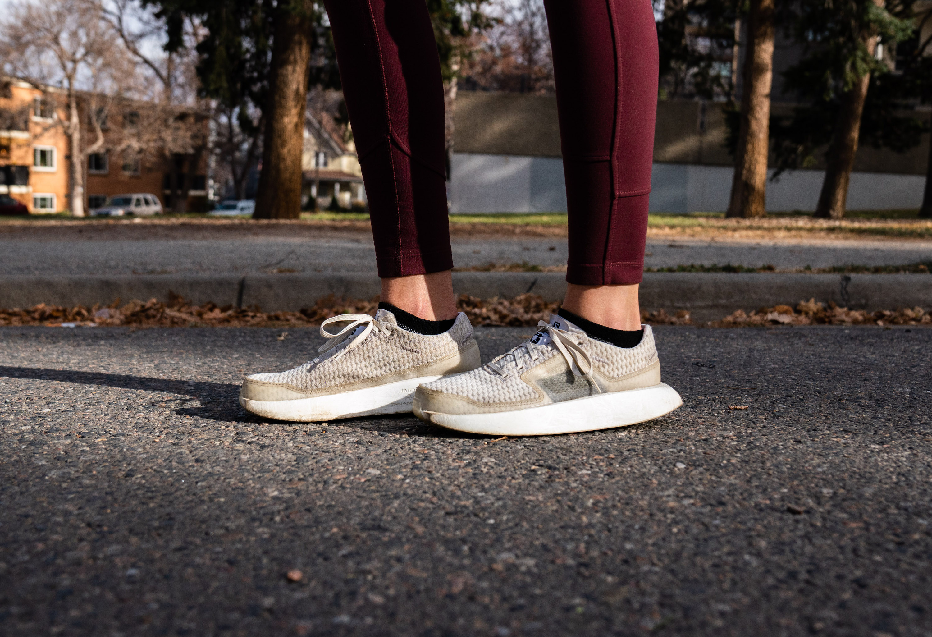 Editor Mary Murphy wearing the recyclable Salomon Index.01 white running shoes pauses on pavement mid-run