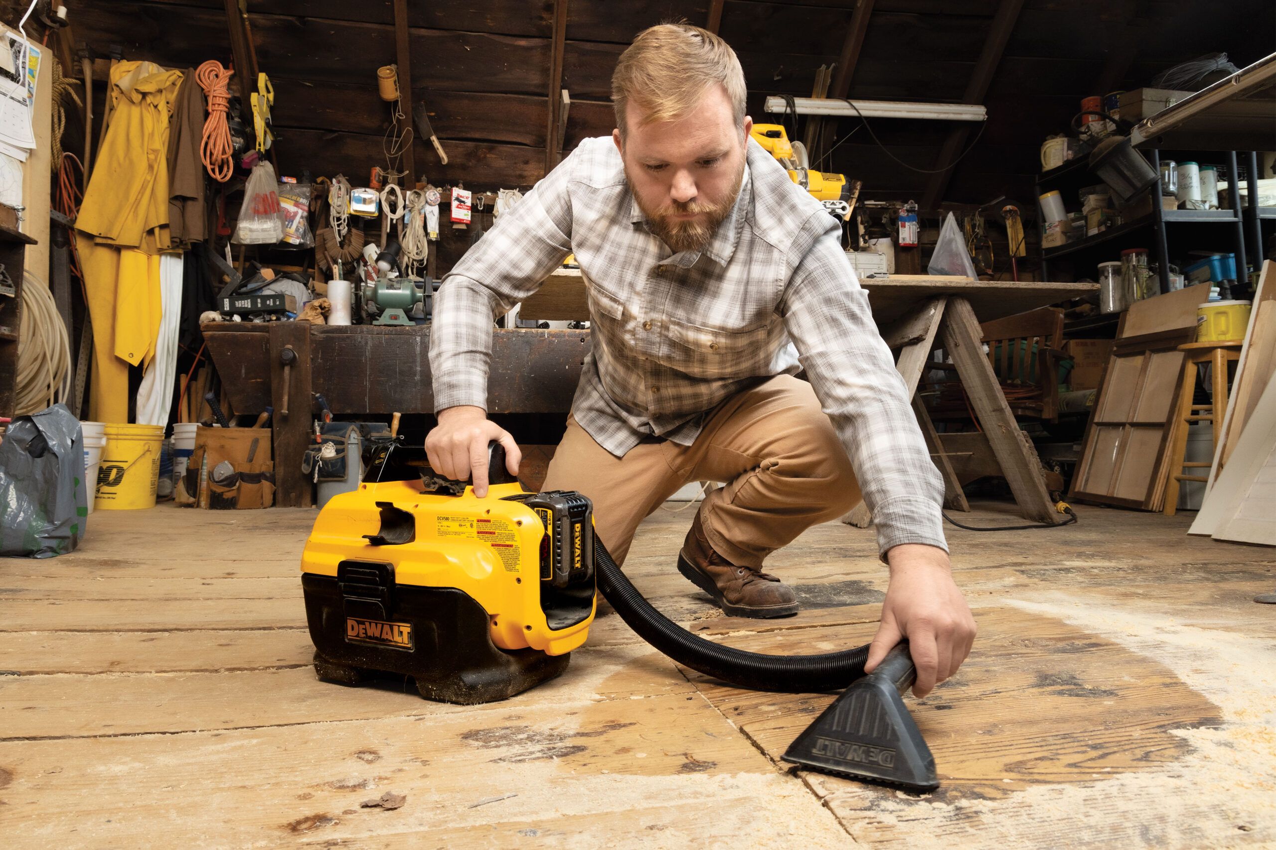 Nathan Gilbert using a small shop vac to clean sawdust