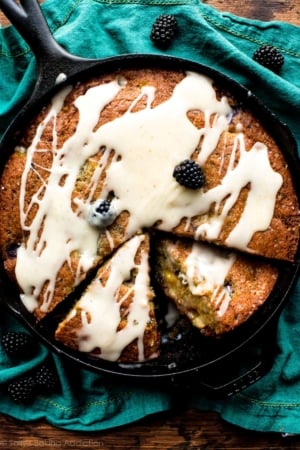 overhead image of blackberry peach skillet cornmeal cake topped with brown butter icing